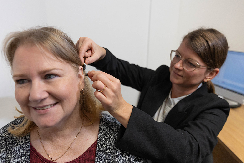 South West Hearing Care celebrates homegrown success audiologist ele kendall, fitting a patient with a hearing aid